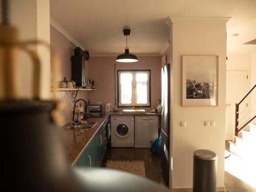 una cucina con lavello e lavatrice di Pina Hideaway with a sea view rooftop terrace a Bicas