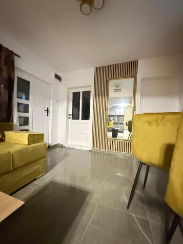 a living room with a yellow couch and a window at Casa Lăpușană in Lăpuş
