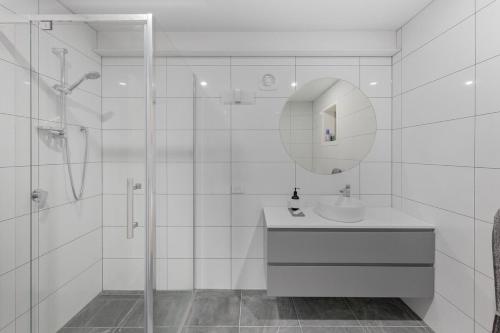een witte badkamer met een wastafel en een spiegel bij Beach House at Quiet Corner in Adventure Bay