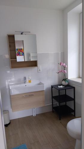 a bathroom with a white sink and a toilet at A la Belle Etoile in Montbrison