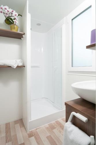 a bathroom with a sink and a glass shower at Wellness Landhaus Parth in Ossiach