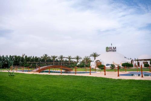 GuemarPalm Garden Souf的公园,公园内有带滑梯的草地