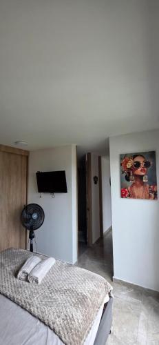 une chambre avec un lit et une télévision à écran plat dans l'établissement VistaVive!, à Ibagué