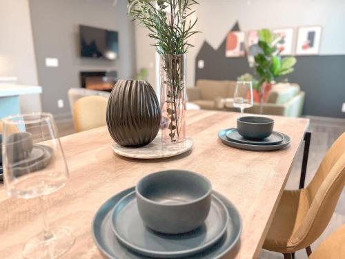 a wooden table with two plates and a vase on it at D Cityscape Getaway Fort Worth SameDay Booking in Fort Worth
