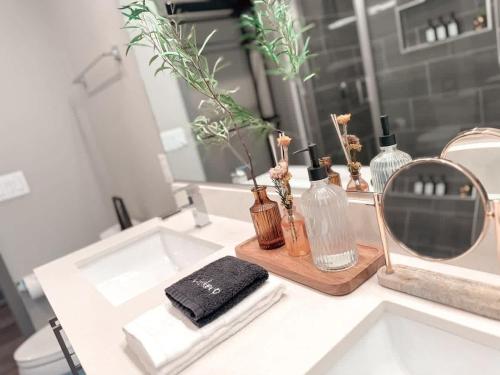 a bathroom sink with a mirror and bottles on it at D Cityscape Getaway Fort Worth SameDay Booking in Fort Worth