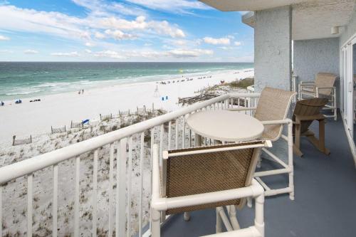 een balkon met een tafel en stoelen en het strand bij Islander FWB 501 Spacious gulf front condo in Fort Walton Beach
