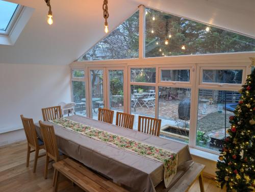 a dining room with a table and a christmas tree at 4bedrooms house sleeps14 Garden&Parking Ably Stays in London