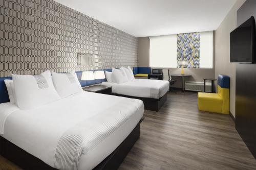 ナッシュビルにあるGLo Best Western Nashville Airportのベッド2台とソファがあるホテルの部屋