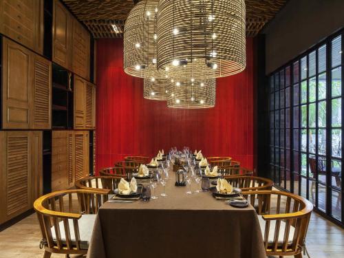 Un comedor con una mesa larga y una lámpara de araña. en Pullman Ciawi Vimala Hills Resort, en Bogor