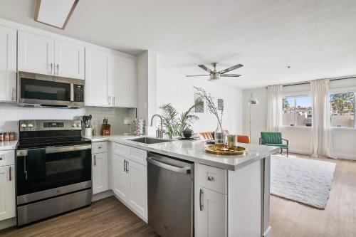 a kitchen with white cabinets and a stove top oven at Modern 1BD in La Jolla Mountain City Views Free Parking in San Diego