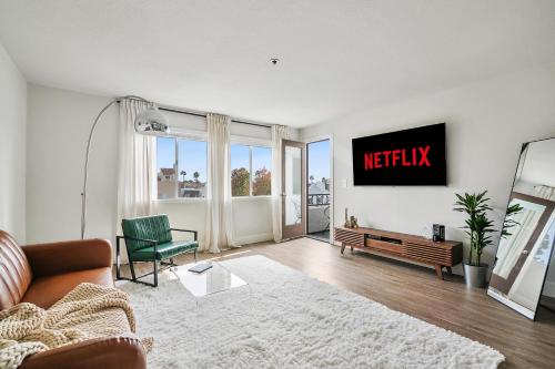 a living room with a couch and a tv on the wall at Modern 1BD in La Jolla Mountain City Views Free Parking in San Diego