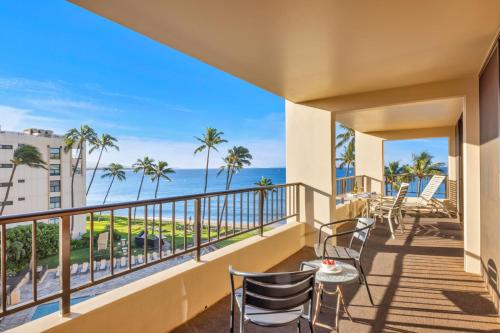 Un balcón con sillas y vista al mar. en Sugar Beach 511, en Kihei