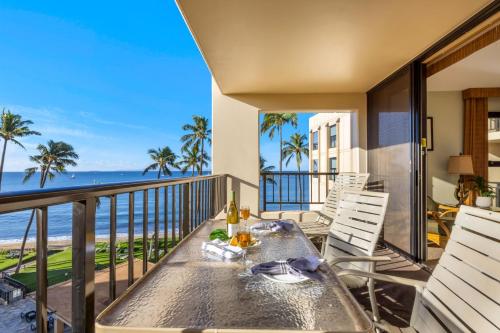 Una mesa en un balcón con vista al mar. en Sugar Beach 511, en Kihei