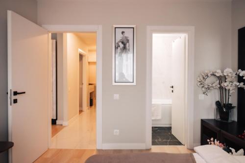 een woonkamer met witte muren en een hal bij Harmony North Two Bedroom in Boekarest