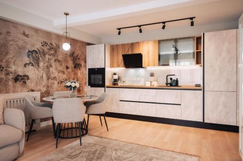 een keuken en woonkamer met een tafel en stoelen bij Harmony North Two Bedroom in Boekarest