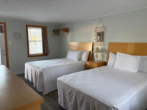 旧奥查德比奇Moontide Motel, Apartments, and Cabins的一间有两张床和一扇窗户的酒店房间
