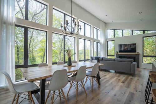 a dining room with a wooden table and chairs at Chalet Le Greenwood - Mountain View & Private Spa in Saint-Faustin