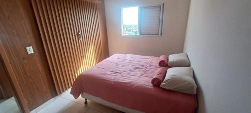 ein kleines Bett in einem Schlafzimmer mit Fenster in der Unterkunft Apartamento mobiliado próximo Unesc em Criciúma in Criciúma