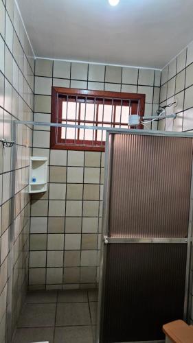 a bathroom with a window and a shower stall at Casa com piscina Perto Da Praia Em FIGUEIRA in Arraial do Cabo