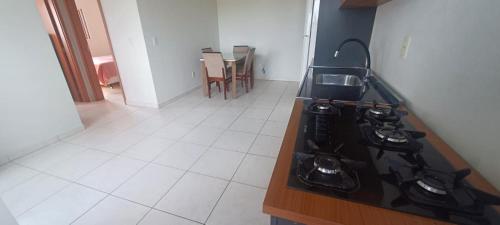 eine Küche mit Herd und Arbeitsplatte in der Unterkunft Apartamento mobiliado próximo Unesc em Criciúma in Criciúma