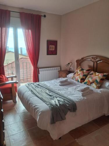 ein Schlafzimmer mit einem großen Bett und einem Fenster in der Unterkunft Casa Guinda in Gavilanes