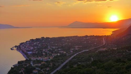 an island in the water with the sunset in the background at Melistas Rooms in Marathiás