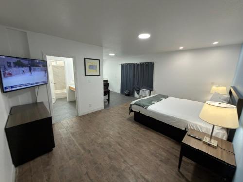 a bedroom with a bed and a flat screen tv at Florentine Motel And Studio in Bell