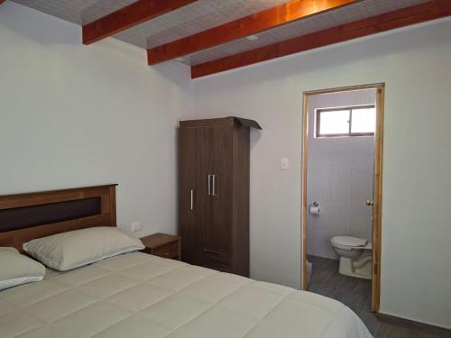 a bedroom with a bed and a bathroom with a toilet at Alto Jere in Toconao