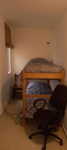 a room with two bunk beds and a chair at El Chalten hospedaje diario in General Pico