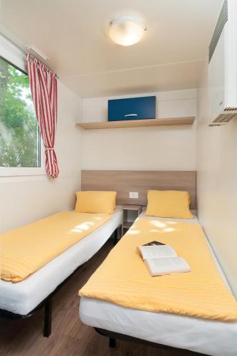 two beds in a small room with a window at Wellness Landhaus Parth in Ossiach