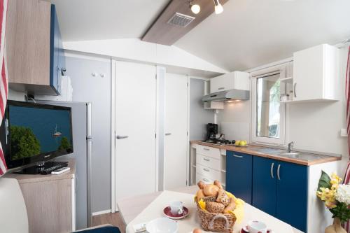 a small kitchen with blue cabinets and a table at Wellness Landhaus Parth in Ossiach