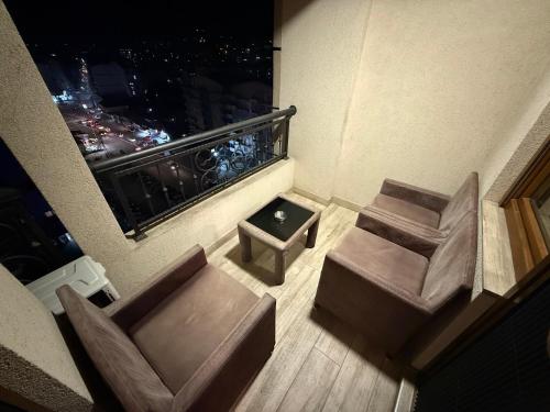 a room with a balcony with a chair and a table at Luka Apartments - Iconic Flatiron - Free Parking in Skopje