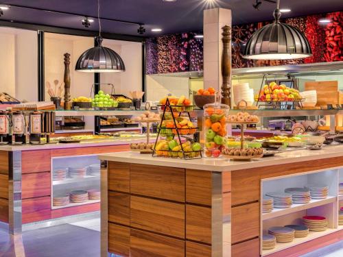 Una panadería con una exhibición de frutas en un mostrador. en Mövenpick Hotel Amsterdam City Centre, en Ámsterdam