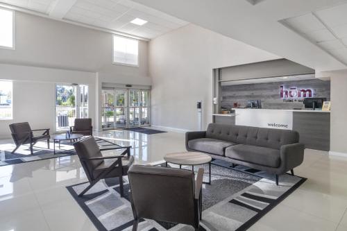 a living room with a couch and a table and chairs at HOM Hotel Gainesville, SureStay Collection by Best Western in Gainesville
