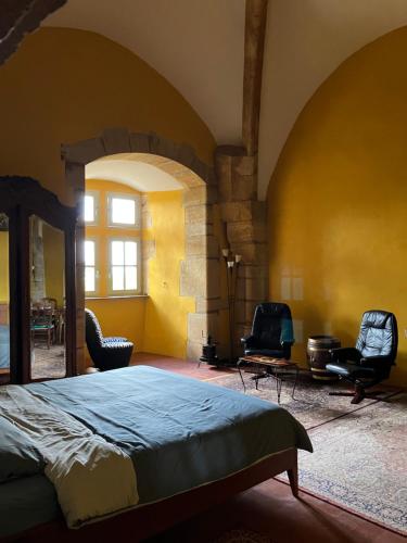 una camera da letto con un letto, due sedie e una finestra di Chateau d'Albon - Saint Andre d'Apchon a Saint-André-dʼApchon