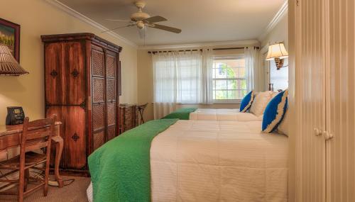 a bedroom with two beds and a ceiling fan at The Caribbean Court Boutique Hotel in Vero Beach