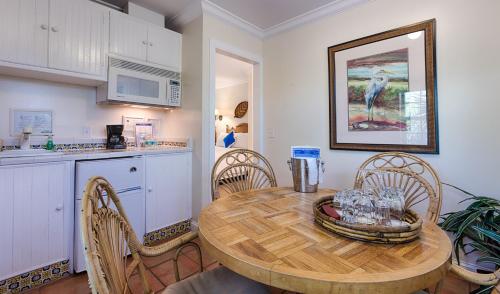 a kitchen with a wooden table and chairs in a kitchen at The Caribbean Court Boutique Hotel in Vero Beach