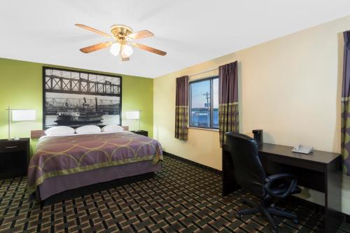 a hotel room with a bed and a desk at Super 8 by Wyndham Marietta in Marietta