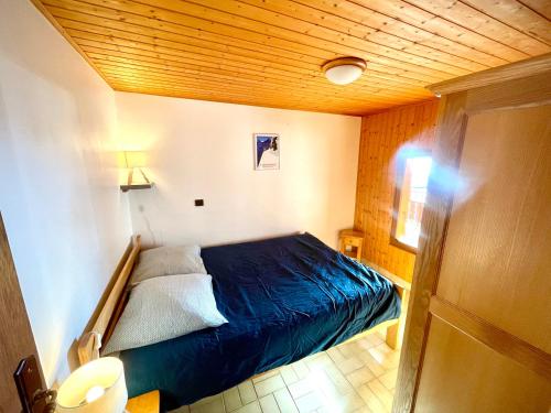 - une chambre avec un lit bleu dans l'établissement CHARMIEUX appartement en chalet typique, au Grand-Bornand