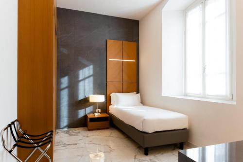 een kleine slaapkamer met een bed en een raam bij Foresteria La Vista in Cremona