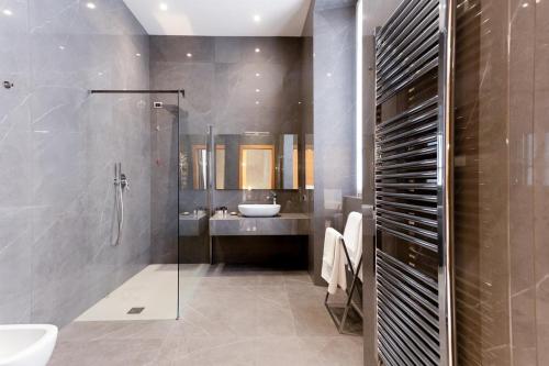 een badkamer met een glazen douche en een wastafel bij Foresteria La Vista in Cremona