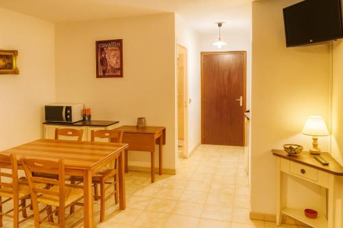 コルテにあるRésidence Talkinon - Saint Pancraceのテーブルと椅子のあるキッチンとダイニングルーム