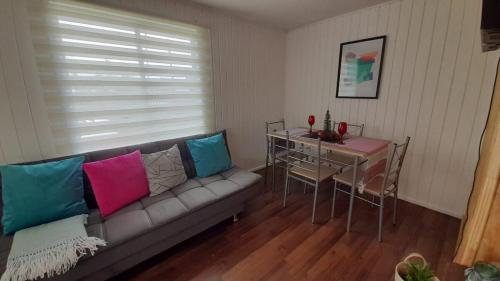 a living room with a couch with colorful pillows at Casa en Puerto Montt in Puerto Montt