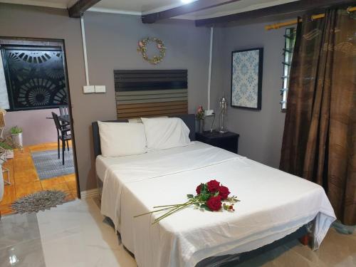 una camera da letto con un letto bianco e un fiore sopra di Master's Homestay a Suva