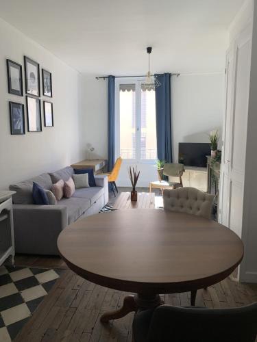 un salon avec une table et un canapé dans l'établissement Le cosy Flachet, à Villeurbanne
