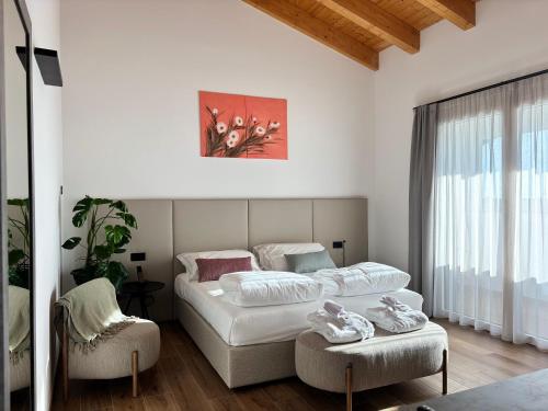 a hotel room with two beds and a chair at Tenuta Tommasi - Relais Bacco in Caorle