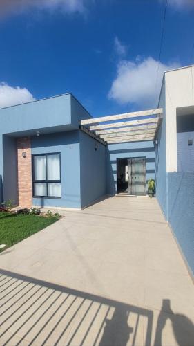 ein blau-weißes Gebäude mit einer Garage in der Unterkunft Jenni's House in Itapoa