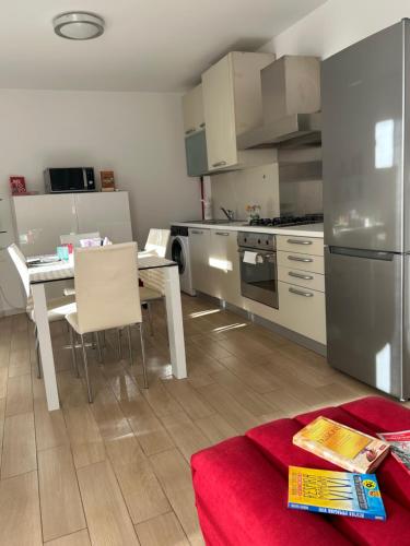 a kitchen with a table and a stainless steel refrigerator at Larocca Tourist Home 6 Bassano in Bassano del Grappa
