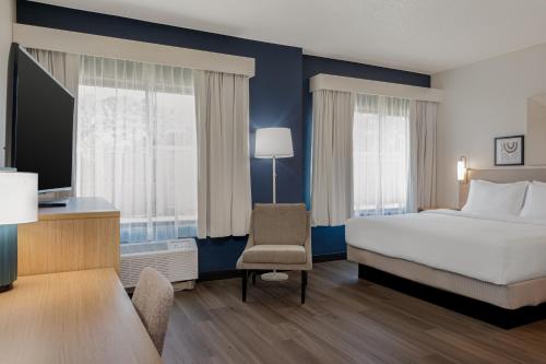 a hotel room with a bed and a chair at Spark By Hilton Wilmington in Wilmington