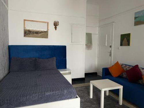 a bedroom with a blue bed and a couch at Studio tres calme Quartier administratif Rabat in Rabat